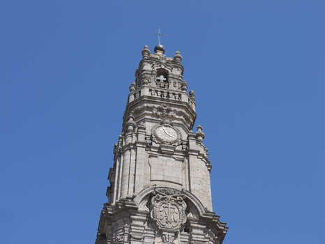 View of the ornate stone facade and clock of the historic Clerigos Tower against a clear blue sky in Porto Porto District Portugal. View of the ornate stone facade and clock of the historic Clerigos Tower against a clear blue sky in Porto Porto District Portugal.