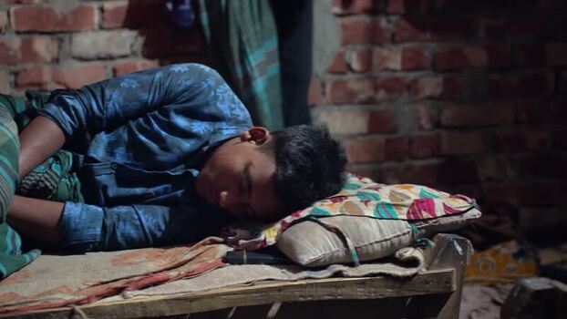 View of a young man sleeping on a wooden bed in Bogura Bangladesh. View of a young man sleeping on a wooden bed in Bogura Bangladesh.