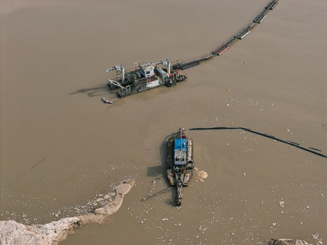 Aerial view of two industrial dredgers operating in a river with floating pipelines and murky water in Dulmen North Rhine Westphalia Germany. Aerial view of two industrial dredgers operating in a river with floating pipelines and murky water in Dulmen North Rhine Westphalia Germany.