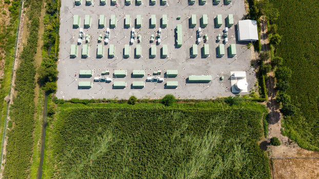 Aerial view of a modern Battery Energy Storage System with rows of green containerized units power transformers and equipment in Tavazzano con Villavesco Lombardy Italy.