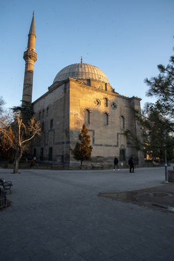 View of the historic Kursunlu Mosque with its large dome and tall minaret under a clear blue sky at sunset in Kayseri Kayseri Turkiye. View of the historic Kursunlu Mosque with its large dome and tall minaret under a clear blue sky at sunset in Kayseri Kayseri Turkiye.
