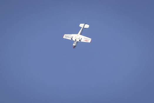 View of a small white airplane flying against a clear blue sky in La Spezia Liguria Italy. View of a small white airplane flying against a clear blue sky in La Spezia Liguria Italy.