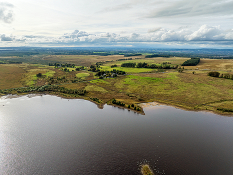 Aerial view of Harperrig Reservoir surrounded by rolling green hills and rural landscape in Kirknewton Scotland United Kingdom. Aerial view of Harperrig Reservoir surrounded by rolling green hills and rural landscape in Kirknewton Scotland United Kingdom.