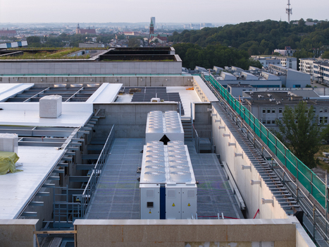 Aerial view of an AI data center rooftop featuring industrial cooling units solar panels and green roof sections overlooking the urban landscape of Krakow Lesser Poland Voivode Poland. Aerial view of an AI data center rooftop featuring industrial cooling units solar panels and green roof sections overlooking the urban landscape of Krakow Lesser Poland Voivode Poland.