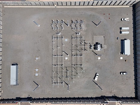 Aerial view of an electrical substation with transformers power lines and utility vehicles on a gravel lot in Thornton Colorado United States. Aerial view of an electrical substation with transformers power lines and utility vehicles on a gravel lot in Thornton Colorado United States.