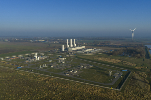 Aerial view of the Nitrogen plant with white chimneys and industrial structures surrounded by green fields and a wind turbine in Zuidbroek Groningen Netherlands. Aerial view of the Nitrogen plant with white chimneys and industrial structures surrounded by green fields and a wind turbine in Zuidbroek Groningen Netherlands.