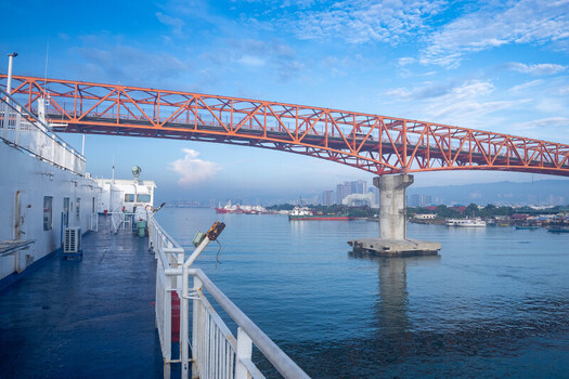 View of the Cebu Port Authority area from a ferry boat passing under the old Mactan Cebu bridge Cebu City Central Visayas Philippines. View of the Cebu Port Authority area from a ferry boat passing under the old Mactan Cebu bridge Cebu City Central Visayas Philippines.