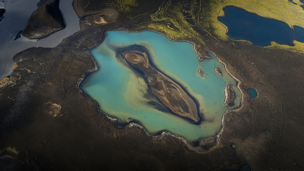 Aerial view of the turquoise waters of Langisjor lake surrounded by dark volcanic terrain and mossy green landscapes in Vik Myrdalshreppur Iceland. Aerial view of the turquoise waters of Langisjor lake surrounded by dark volcanic terrain and mossy green landscapes in Vik Myrdalshreppur Iceland.