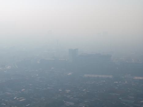 Surabaya Indonesia 05 August 2026 Aerial view of the city of Surabaya shrouded in thick smog with buildings and residential rooftops partially obscured by heavy air pollution.
