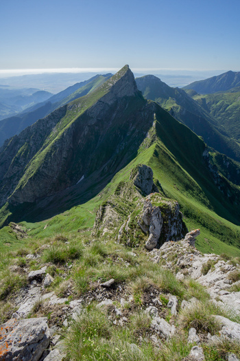 View of the sharp peak of Zdiarska vidla with green mountain ridges and rocky outcrops under a clear blue sky in Zdiar Presov Region Slovakia. View of the sharp peak of Zdiarska vidla with green mountain ridges and rocky outcrops under a clear blue sky in Zdiar Presov Region Slovakia.
