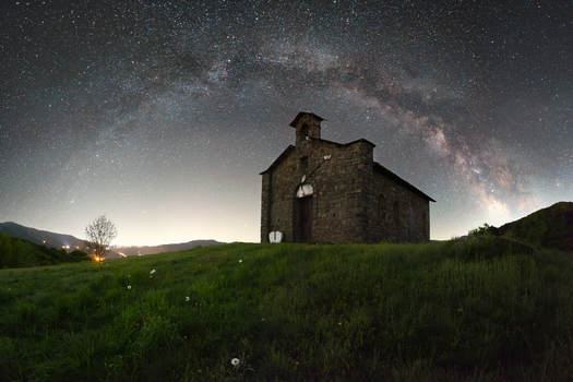 View of the stone chapel at Passo di Cirone under the arching Milky Way galaxy and a starry night sky Pontremoli Toscana Italy. View of the stone chapel at Passo di Cirone under the arching Milky Way galaxy and a starry night sky Pontremoli Toscana Italy.