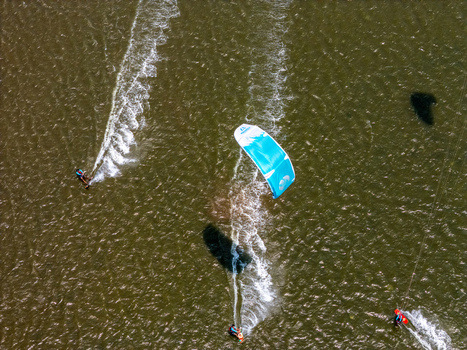 Aerial view of kite surfers gliding across the water at Depok Beach in the Special Region of Yogyakarta Indonesia.