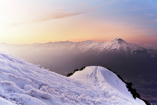 View of the snow covered peaks of the Lake Como Mountains at sunset with dramatic golden light illuminating the alpine landscape in Lombardy Italy. View of the snow covered peaks of the Lake Como Mountains at sunset with dramatic golden light illuminating the alpine landscape in Lombardy Italy.