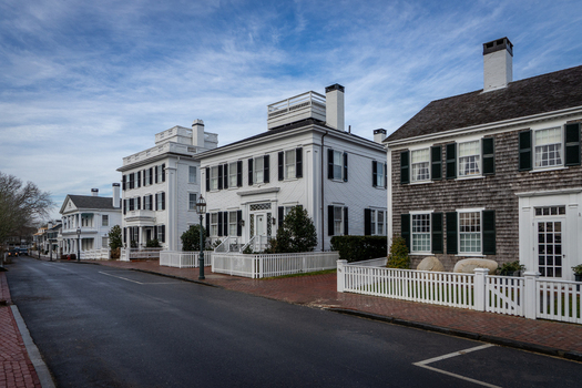 View of historic houses with white fences and black shutters along a quiet street on Martha s Vineyard in Edgartown Massachusetts United States.