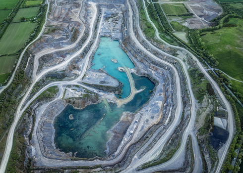 Aerial view of the Irish Cement Ltd quarry featuring turquoise water pools and terraced stone walls surrounded by green fields in Drogheda County Louth Ireland. Aerial view of the Irish Cement Ltd quarry featuring turquoise water pools and terraced stone walls surrounded by green fields in Drogheda County Louth Ireland.