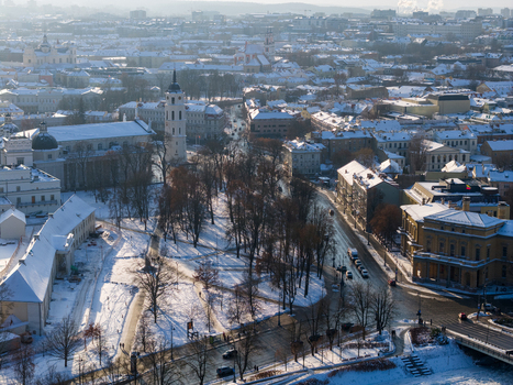 Aerial view of Vilnius Cathedral and bell tower surrounded by snow covered rooftops and streets in winter Vilnius County Lithuania.