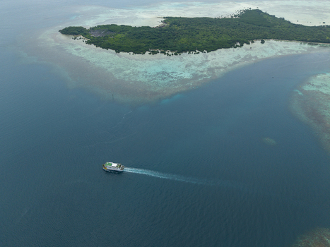 Aerial view of a ferry cuts through the turquoise waters near a lush island paradise Karimunjawa Jawa Tengah Indonesia. Aerial view of a ferry cuts through the turquoise waters near a lush island paradise Karimunjawa Jawa Tengah Indonesia.
