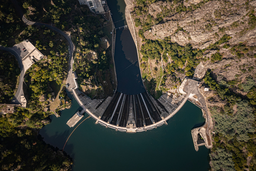Aerial view of Encoro de Santo Estevo dam spanning the Sil River surrounded by steep rocky cliffs and lush green vegetation Ourense Ourense Spain. Aerial view of Encoro de Santo Estevo dam spanning the Sil River surrounded by steep rocky cliffs and lush green vegetation Ourense Ourense Spain.
