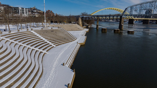 Aerial view of the snow covered Serpentine Wall at Smale Riverfront Park along the Ohio River with the Big Mac Bridge in the background in Cincinnati Ohio United States. Aerial view of the snow covered Serpentine Wall at Smale Riverfront Park along the Ohio River with the Big Mac Bridge in the background in Cincinnati Ohio United States.