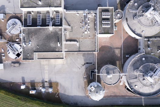 Aerial view of the Lulu Island Wastewater Treatment Plant featuring circular sedimentation tanks and industrial infrastructure in Richmond British Columbia Canada. Aerial view of the Lulu Island Wastewater Treatment Plant featuring circular sedimentation tanks and industrial infrastructure in Richmond British Columbia Canada.