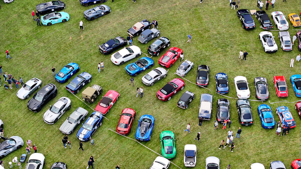 La Chapelle de Guinchay France 01 June 2024 Aerial view of a large gathering of colorful sports and vintage cars parked on a green grass field with people walking between the rows. La Chapelle de Guinchay France 01 June 2024 Aerial view of a large gathering of colorful sports and vintage cars parked on a green grass field with people walking between the rows.