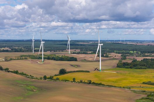 Aerial view of wind turbines standing in the rural landscape of Pomeranian Voivodeship Poland.