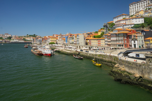 Aerial view of the vibrant Ribeira district s colorful buildings reflecting on the Douro River under a clear sky Porto Porto District Portugal. Aerial view of the vibrant Ribeira district s colorful buildings reflecting on the Douro River under a clear sky Porto Porto District Portugal.