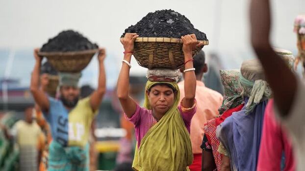 View of workers carrying coal baskets in Aminbazar Bangladesh. View of workers carrying coal baskets in Aminbazar Bangladesh.
