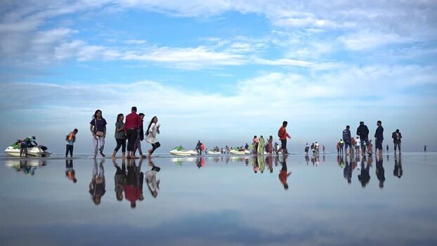 View of people walking on the wet sands of Cox s Bazar Bangladesh. View of people walking on the wet sands of Cox s Bazar Bangladesh.