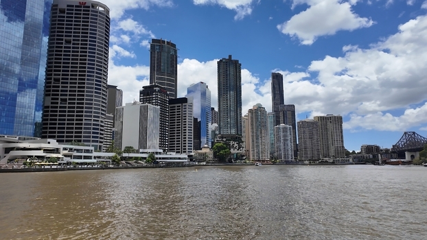View of the Brisbane city skyline featuring modern skyscrapers the Brisbane River and the Story Bridge under a blue sky with clouds in Brisbane Queensland Australia. View of the Brisbane city skyline featuring modern skyscrapers the Brisbane River and the Story Bridge under a blue sky with clouds in Brisbane Queensland Australia.