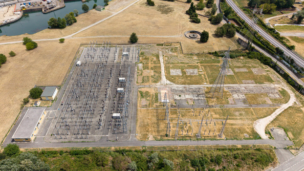 Aerial view of the electrical substation with high voltage power lines and transformers surrounded by dry fields in Tavazzano con Villavesco Lombardy Italy.