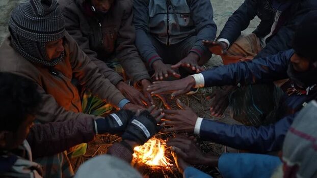 View of people warming hands by a fire in Bogura Bangladesh. View of people warming hands by a fire in Bogura Bangladesh.