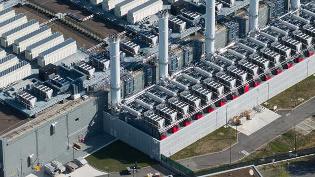 Aerial view of an industrial facility featuring numerous cooling units and tall chimneys set within a modern complex in Dietzenbach Hessen Germany. Aerial view of an industrial facility featuring numerous cooling units and tall chimneys set within a modern complex in Dietzenbach Hessen Germany.