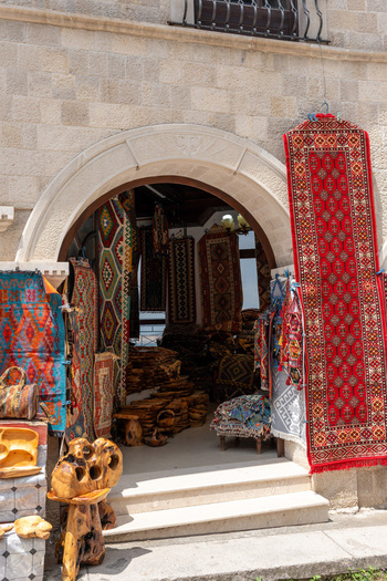View of a traditional shop entrance with colorful handmade carpets and wooden crafts displayed in the historic bazaar of Kruje Durres County Albania.