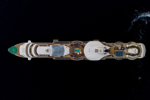 Aerial view of a large cruise ship sailing on the deep blue sea with visible decks swimming pools and a helipad in Cannes Provence Alpes Cote d Azur France. Aerial view of a large cruise ship sailing on the deep blue sea with visible decks swimming pools and a helipad in Cannes Provence Alpes Cote d Azur France.