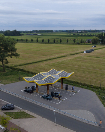 Aerial view of the Fastned Charging Station with solar panels and electric vehicles parked in a rural landscape in Beesd Gelderland Netherlands. Aerial view of the Fastned Charging Station with solar panels and electric vehicles parked in a rural landscape in Beesd Gelderland Netherlands.