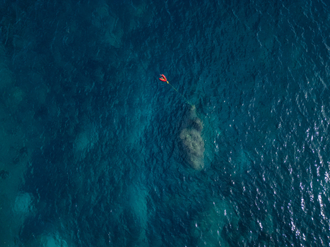 Aerial view of a red buoy floating in the deep blue waters of Cala Llebeig in El Poble Nou de Benitatxell Valencian Community Spain.
