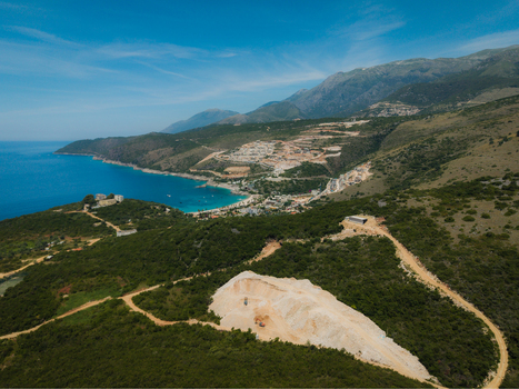 Aerial view of Aquarium Beach and the turquoise coastline surrounded by lush green hills and rugged mountains in Jala Vlore County Albania. Aerial view of Aquarium Beach and the turquoise coastline surrounded by lush green hills and rugged mountains in Jala Vlore County Albania.