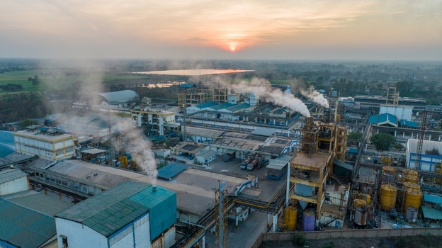 Aerial view of an industrial factory complex with smoking chimneys during a golden sunset in Nagda Madhya Pradesh India. Aerial view of an industrial factory complex with smoking chimneys during a golden sunset in Nagda Madhya Pradesh India.