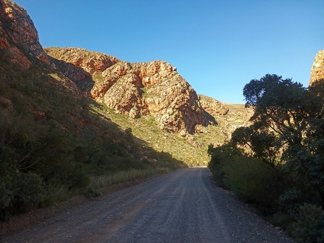View of a dirt road winding through the rugged rocky mountains of the Klein Karoo in Robertson Western Cape South Africa. View of a dirt road winding through the rugged rocky mountains of the Klein Karoo in Robertson Western Cape South Africa.