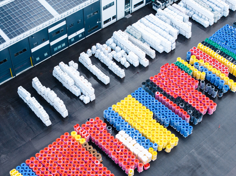 Aerial view of a manufacturing facility yard filled with stacks of colorful polymer pipes and white wrapped materials in Jelgava Latvia. Aerial view of a manufacturing facility yard filled with stacks of colorful polymer pipes and white wrapped materials in Jelgava Latvia.