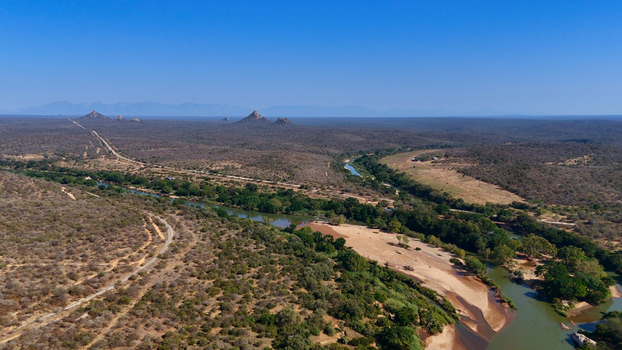 Aerial view of the Olifants River winding through the dry savanna landscape with lush riverine vegetation sandy banks and distant mountains in Hoedspruit Limpopo South Africa. Aerial view of the Olifants River winding through the dry savanna landscape with lush riverine vegetation sandy banks and distant mountains in Hoedspruit Limpopo South Africa.