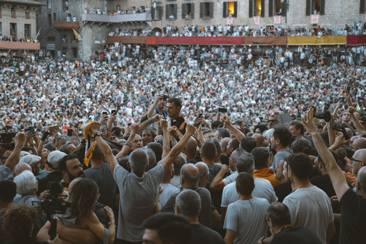 Siena Italy 17 August 2024 View of vibrant crowd celebrating Siena s Palio in historic Piazza del Campo Siena Italy.