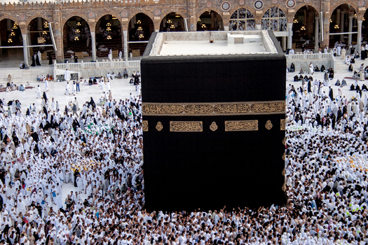 Aerial view of the Kaaba at Masjid al Haram surrounded by a large crowd of pilgrims in white ihram clothing in Makkah Makkah Province Saudi Arabia. Aerial view of the Kaaba at Masjid al Haram surrounded by a large crowd of pilgrims in white ihram clothing in Makkah Makkah Province Saudi Arabia.