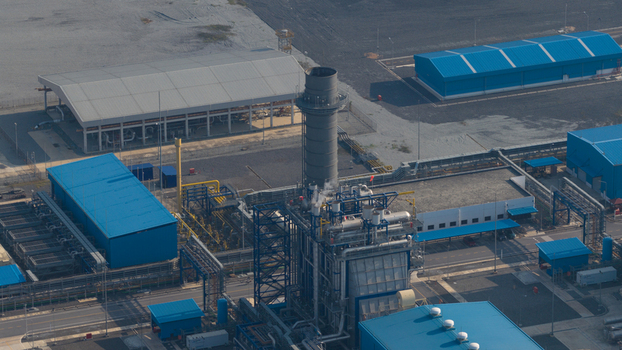 Aerial view of the Gulf Pluak Daeng Power Plant GPD with a tall exhaust stack blue warehouses and intricate pipeline systems in Map Yang Phon Rayong Thailand. Aerial view of the Gulf Pluak Daeng Power Plant GPD with a tall exhaust stack blue warehouses and intricate pipeline systems in Map Yang Phon Rayong Thailand.