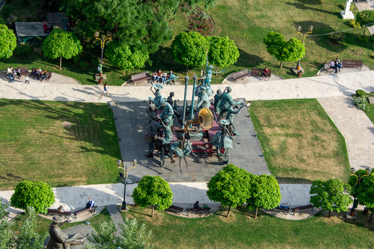 View of the Caragiale Monument surrounded by green lawns trees and park benches with people relaxing in the city center of Bucharest Bucharest Romania. View of the Caragiale Monument surrounded by green lawns trees and park benches with people relaxing in the city center of Bucharest Bucharest Romania.
