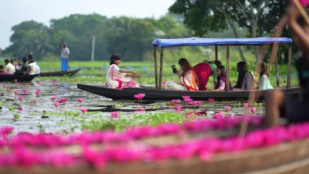 View of people on boats in a water lily pond Bangladesh. View of people on boats in a water lily pond Bangladesh.