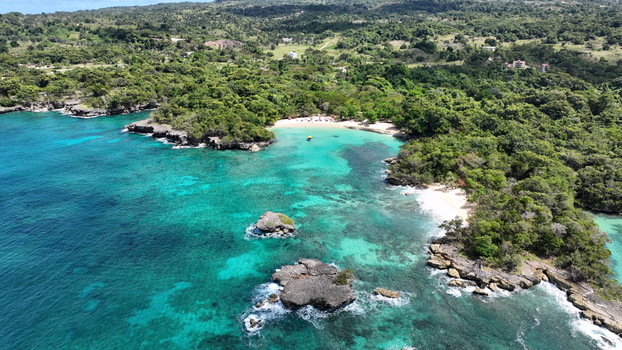 Aerial view of La Casita de Playa featuring turquoise waters rocky islets and lush tropical vegetation along the coastline in Rio San Juan Maria Trinidad Sanchez Dominican Republic.
