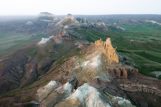Aerial view of the dramatic rocky formations of Airakty mountains surrounded by green valleys and desert landscape in Shetpe Mangystau Region Kazakhstan.