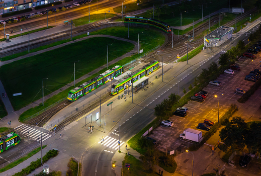 Aerial view of Jana III Sobieskiego Bus and Tram Terminal at night with illuminated green trams on tracks surrounding roads and parking lot in Poznan Greater Poland Voivod Poland. Aerial view of Jana III Sobieskiego Bus and Tram Terminal at night with illuminated green trams on tracks surrounding roads and parking lot in Poznan Greater Poland Voivod Poland.